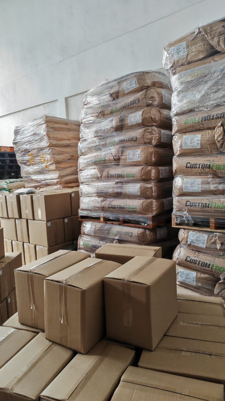 Pallets of sacked raw material stacked beside cartons in the Beyond Lohas store
