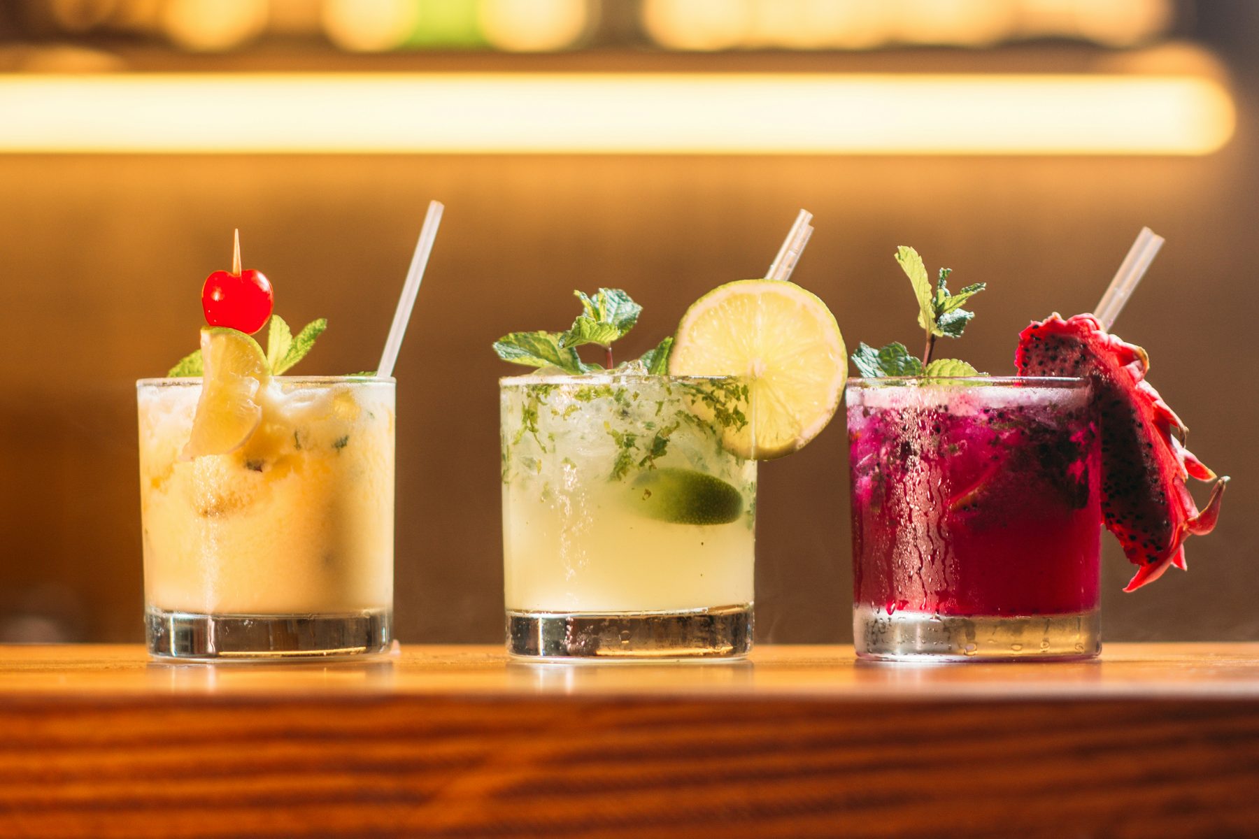Three different beverages lined up on a counter, each served under its own brand