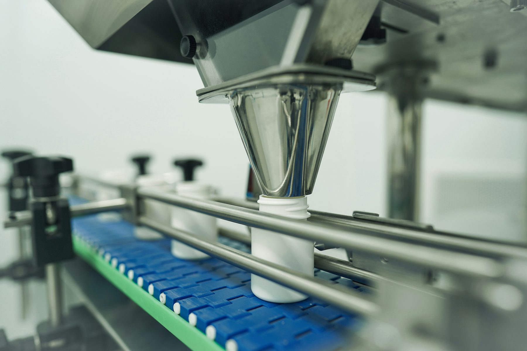 An automated filling line dosing product into containers on a moving conveyor